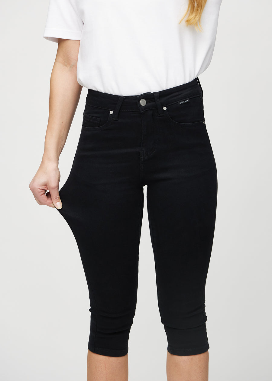 Das Model zieht die Capris am Oberschenkel auseinander, um den Stretch zu zeigen.