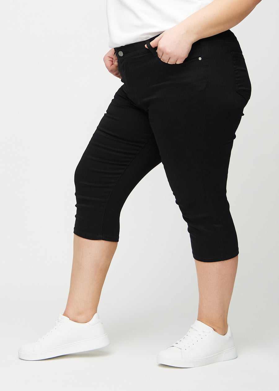 Schwarze skinny Capris, von der Seite an einem Plus-Size-Model gesehen.