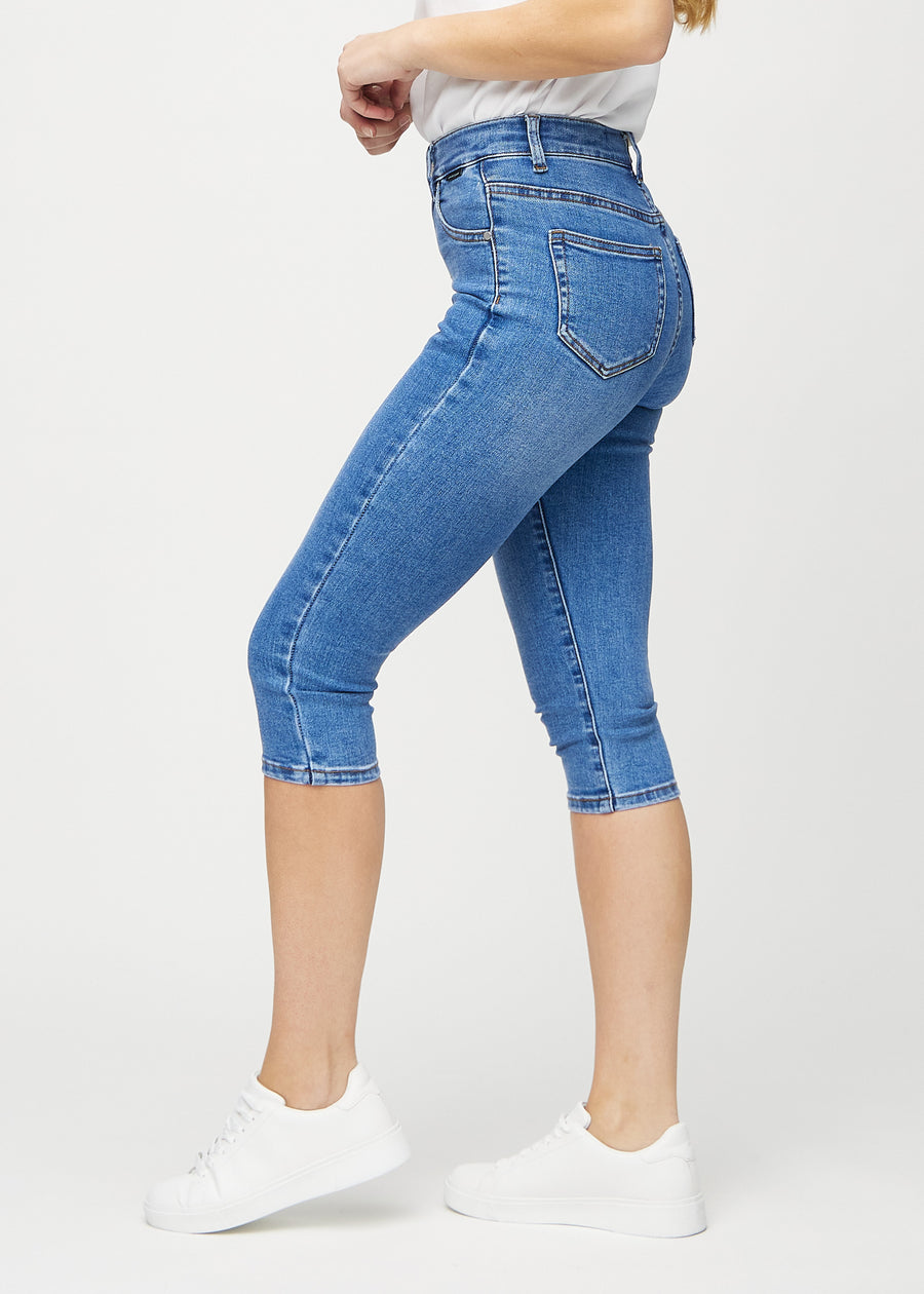 Skinny-Capris für Damen in blauem Denim, Farbe Rivers. Seitenansicht an einem Model, die figurbetonte Passform ist zu sehen.
