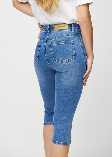 Skinny-Capris für Damen in blauem Denim, Farbe Rivers. Nahaufnahme von hinten an einem Model, zeigt Taschen und Nähte.