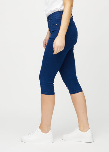 Skinny-Capris für Damen in dunkelblauem Jeansstoff, Farbe Royals. Seitenansicht an einem Model, die figurbetonte Passform ist zu sehen.