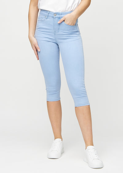 Skinny-Capris für Damen in hellblauem Jeansstoff, Farbe Skies. Vorderansicht an einem Model, eng geschnitten bis knapp unter das Knie.