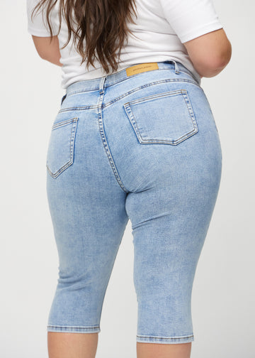 Skinny-Capris für Damen in hellblauem Denim, Farbe Waves. Nahaufnahme von hinten an einem Plus-Size-Model, zeigt Taschen und Nähte.
