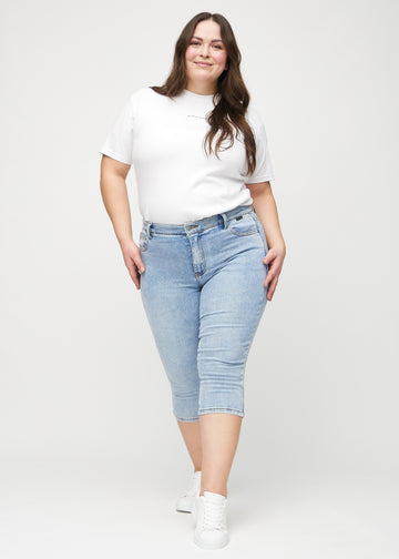 Skinny-Capris für Damen in hellblauem Denim, Farbe Waves. Ganzkörperansicht eines Plus-Size-Models in den Capris.