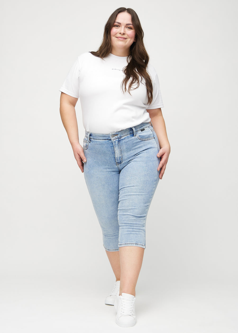 Skinny-Capris für Damen in hellblauem Denim, Farbe Waves. Ganzkörperansicht eines Plus-Size-Models in den Capris.