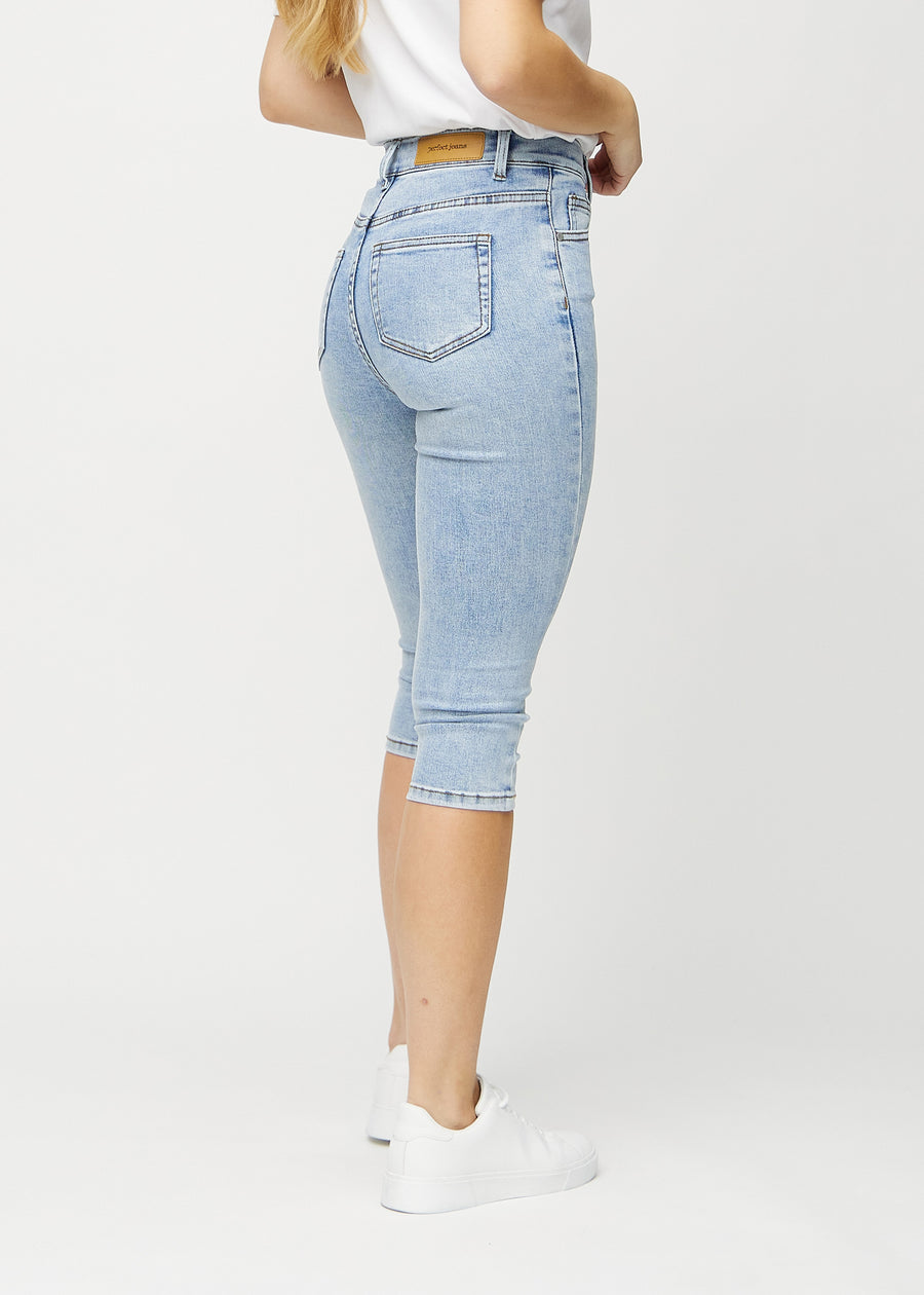 Skinny-Capris für Damen in hellblauem Denim, Farbe Waves. Rückansicht an einem Model, zeigt die Passform und Gesäßtaschen.