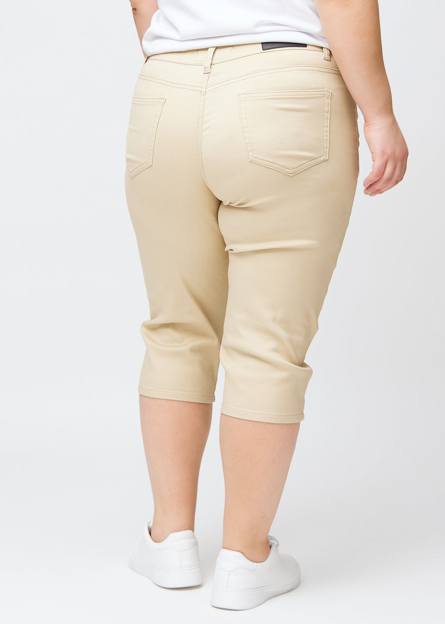 Slim-Capris für Damen aus beigefarbenem Jeansstoff, Farbe Gazelles. Rückansicht an einem Plus-Size-Model, zeigt Passform, Länge und Gesäßtaschen.