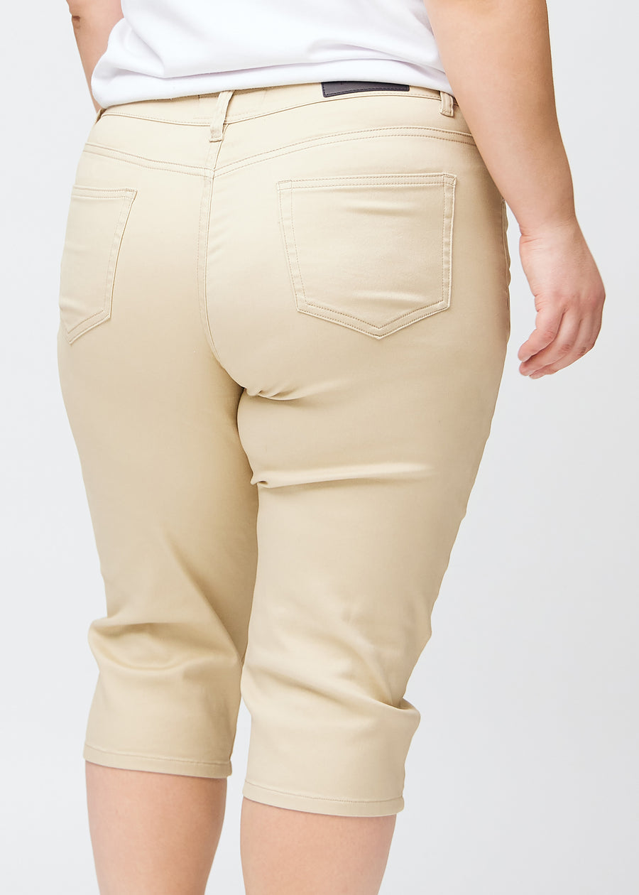 Slim-Capris für Damen aus beigefarbenem Jeansstoff, Farbe Gazelles. Nahaufnahme von hinten an einem Plus-Size-Model, zeigt Taschen und Nähte.
