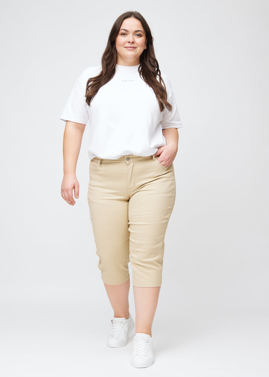 Slim-Capris für Damen aus beigefarbenem Jeansstoff, Farbe Gazelles. Ganzkörperansicht eines Plus-Size-Models in den Slim-Capris.