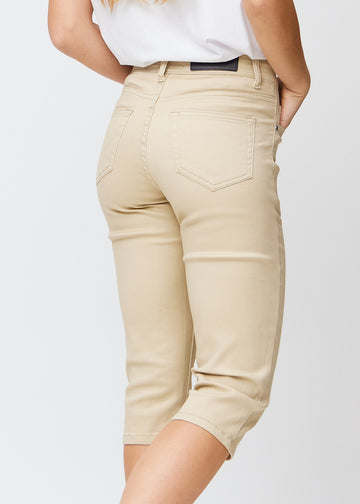 Slim-Capris für Damen aus beigefarbenem Jeansstoff, Farbe Gazelles. Nahaufnahme von hinten an einem Model, zeigt Taschen und Nähte.