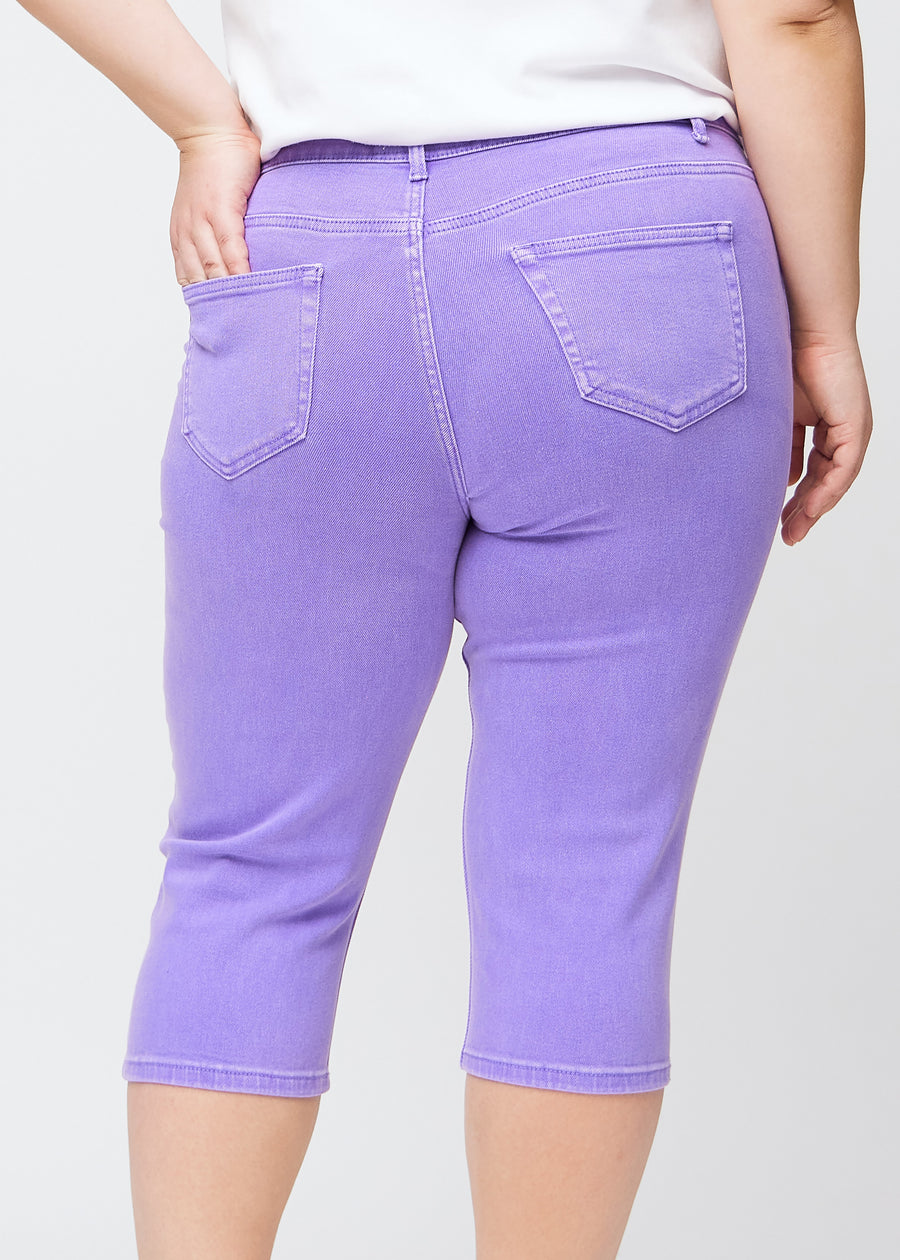 Slim-Capris für Damen aus pastellviolettem Jeansstoff, Farbe Lavenders. Nahaufnahme von hinten an einem Plus-Size-Model, zeigt Taschen und Nähte.