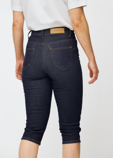 Tief dunkelblaue Denim-Capris für Damen in der Farbe Midnights von hinten nah aufgenommen, um Passform und Details zu zeigen.