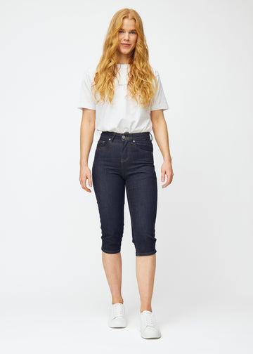 Ganzkörperbild eines Models in tief dunkelblauen Denim-Capris für Damen in der Farbe Midnights mit Slim-Passform.