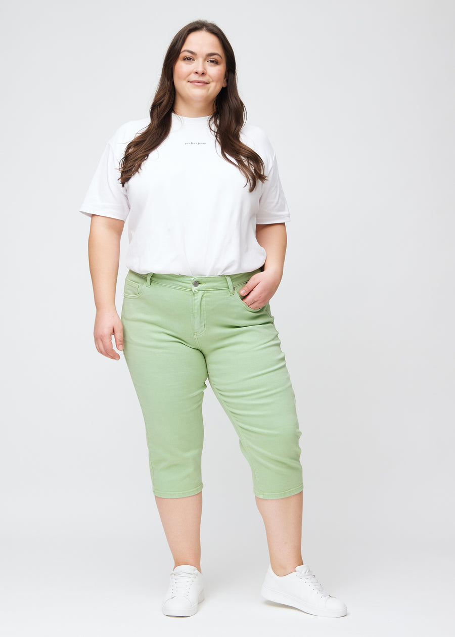 Ganzkörperbild eines Plus-Size-Models in hellgrünen slim Capris.