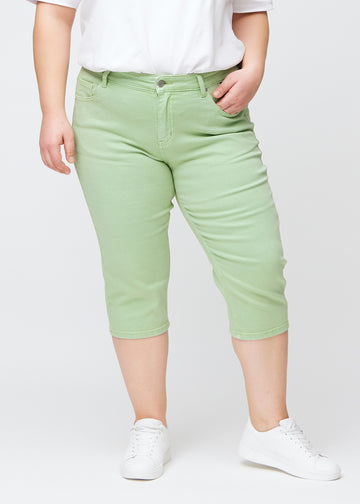 Hellgrüne slim Capris, Farbe Mints, mit enger Passform und einer Länge knapp unter dem Knie, Vorderansicht an einem Plus-Size-Model.