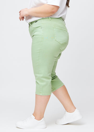 Hellgrüne slim Capris in der Farbe Mints, von der Seite an einem Plus-Size-Model gesehen.
