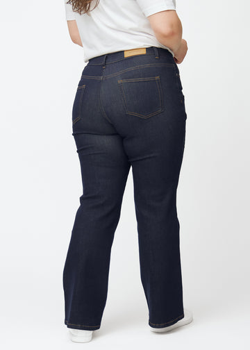 Tief dunkelblaue Denim jeans für Damen in der Farbe Midnights von hinten an einem Plus-Size-Model gezeigt.