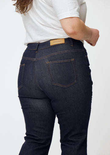 Tief dunkelblaue Denim jeans für Damen in der Farbe Midnights von hinten in Nahaufnahme an einem Plus-Size-Model gezeigt.