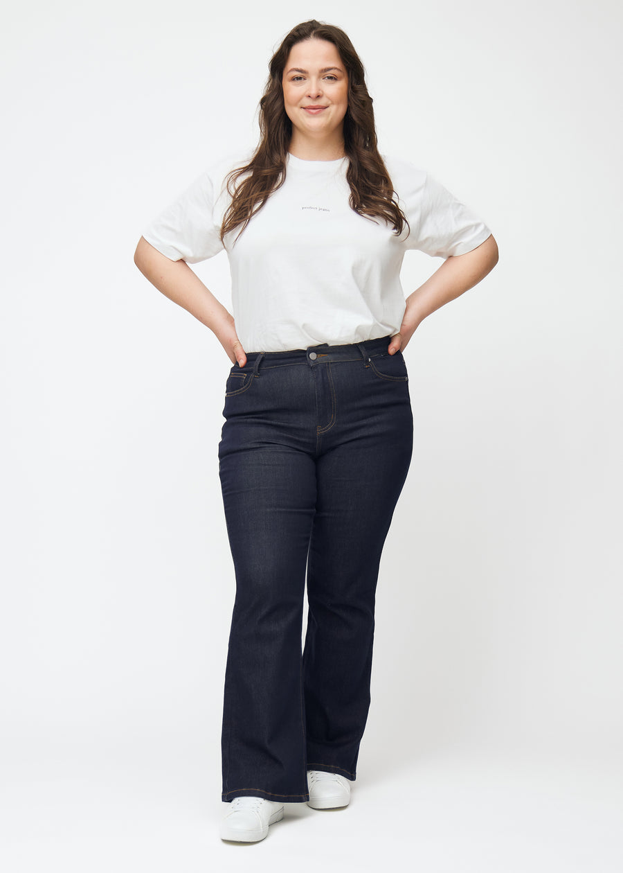 Ganzkörperbild eines Plus-Size-Models in tief dunkelblauer Denim jeans für Damen in der Farbe Midnights mit Bootcut-Passform.