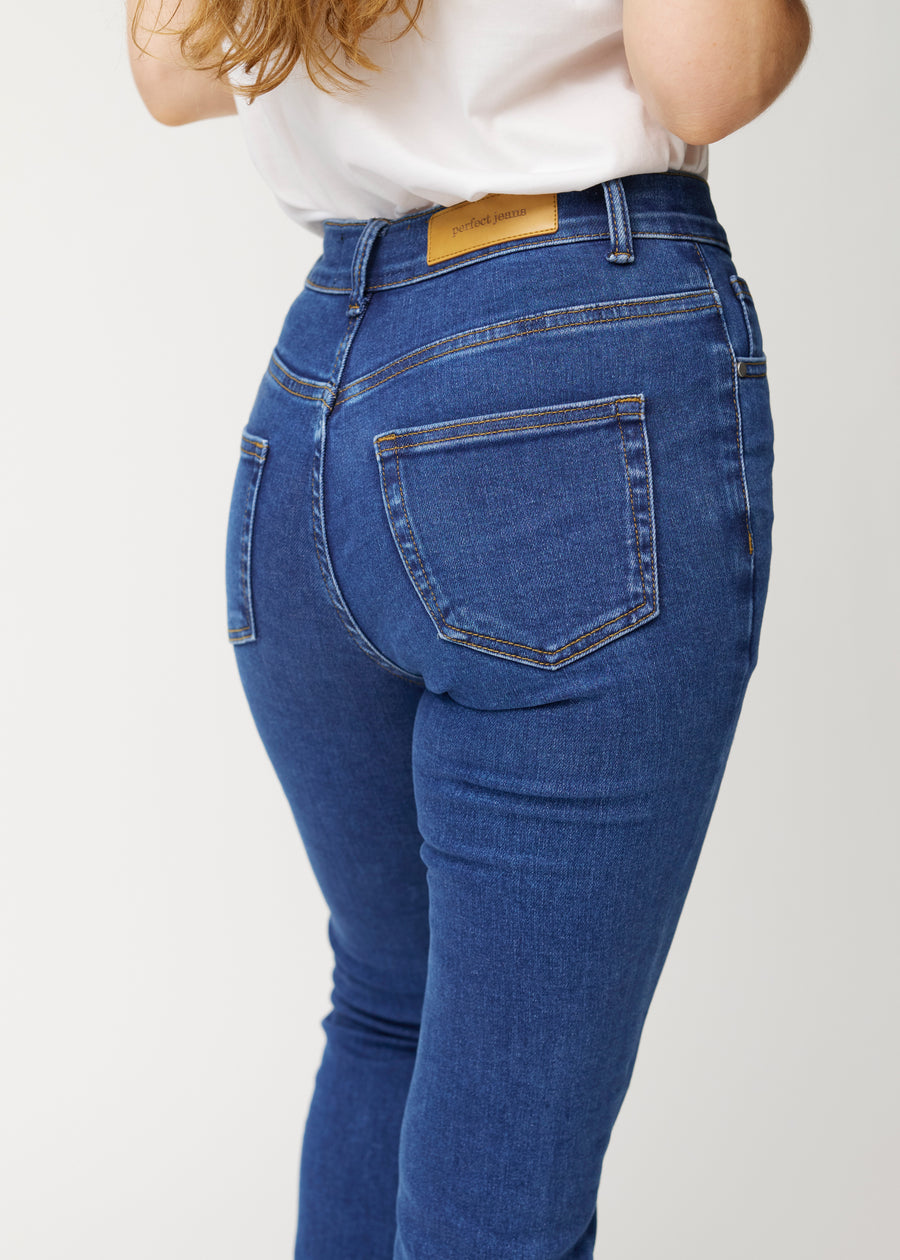 Dunkelblaue Mid-Rise-Bootcut-Jeans in der Farbe Oceans. Nahaufnahme der Rückseite an einem Model, um Details zu zeigen.