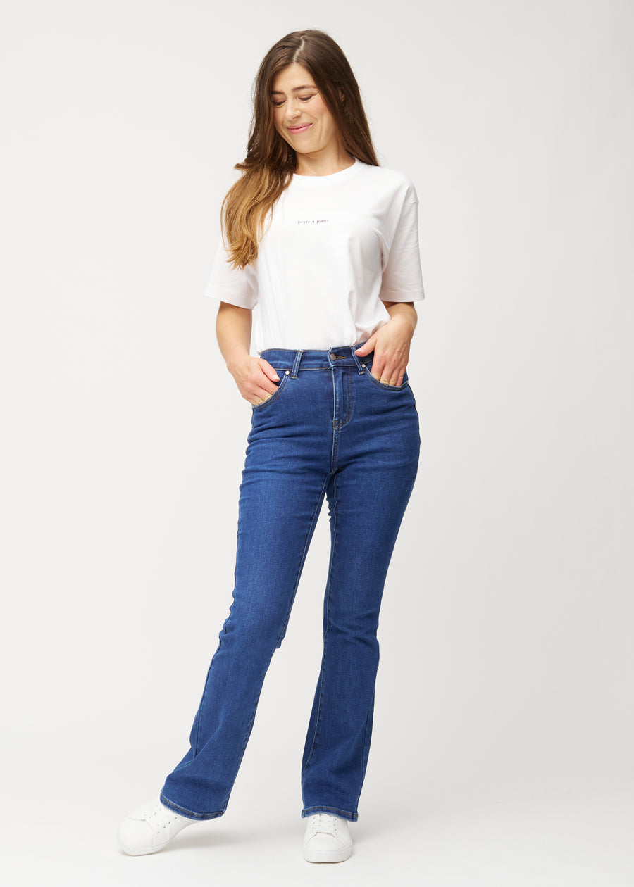 Dunkelblaue Mid-Rise-Bootcut-Jeans in der Farbe Oceans. Ganzkörperansicht eines Model in den Jeans.