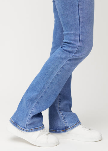 Blaue Mid-Rise-Bootcut-Jeans in der Farbe Rivers. Nahaufnahme am Knöchel eines Model, um den leichten Schlag am Beinabschluss zu zeigen.