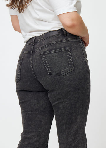 Dunkelgraue Mid-Rise-Bootcut-Jeans in der Farbe Shadows. Nahaufnahme der Rückseite an einem Plus-Size-Model, um Details zu zeigen.