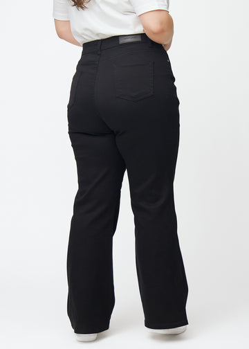 Schwarze hochtaillierte Bootcut jeans von hinten an einem Plus-Size-Model gesehen, damit man das gesamte Produkt sehen kann.