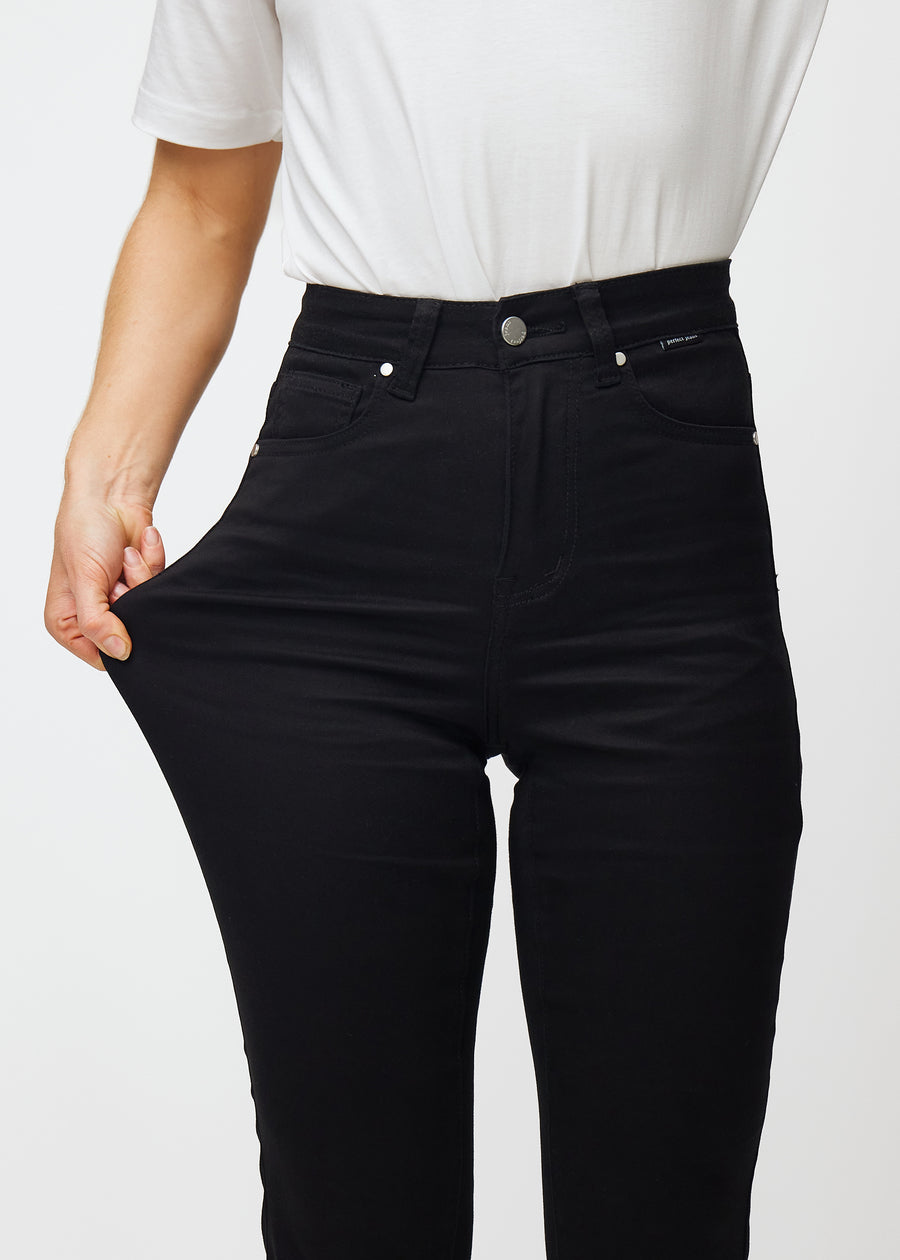 Das Model zieht die Jeans am Oberschenkel, um den Stretch zu zeigen.