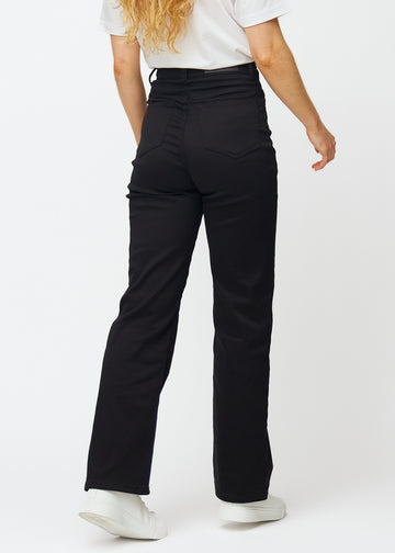 Schwarze hochtaillierte jeans, die an der Taille eng anliegen und eine lockere Passform mit Weite nach unten haben, von hinten gesehen, um das gesamte Produkt zu zeigen.