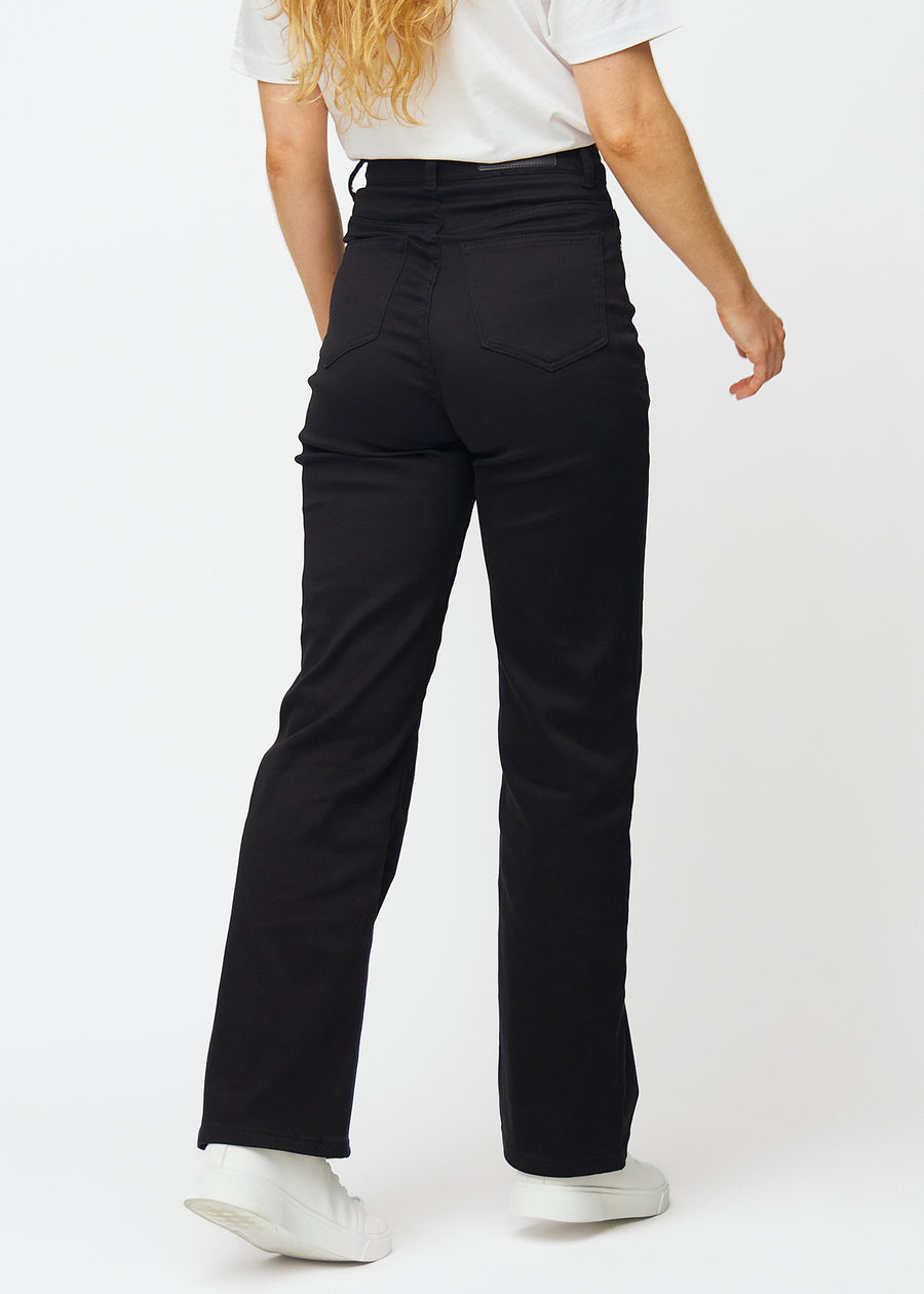 Schwarze hochtaillierte jeans, die an der Taille eng anliegen und eine lockere Passform mit Weite nach unten haben, von hinten gesehen, um das gesamte Produkt zu zeigen.