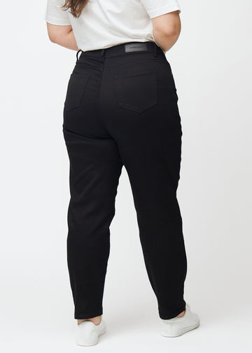 Schwarze hochtaillierte regular jeans von hinten an einem Plus-Size-Model gesehen, damit man das ganze Produkt sehen kann.