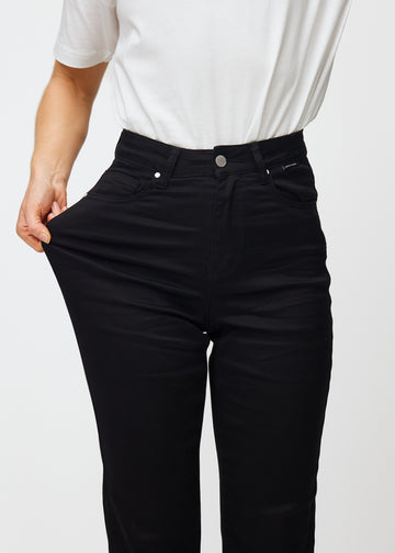 Das Model zieht die Jeans am Oberschenkel auseinander, um den Stretch zu zeigen.