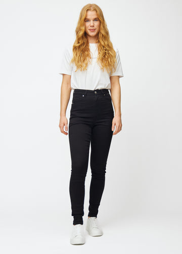 Das Bild zeigt ein komplettes Outfit mit einem Model in schwarzen High-Rise-skinny jeans für Damen in der Farbe Ravens.