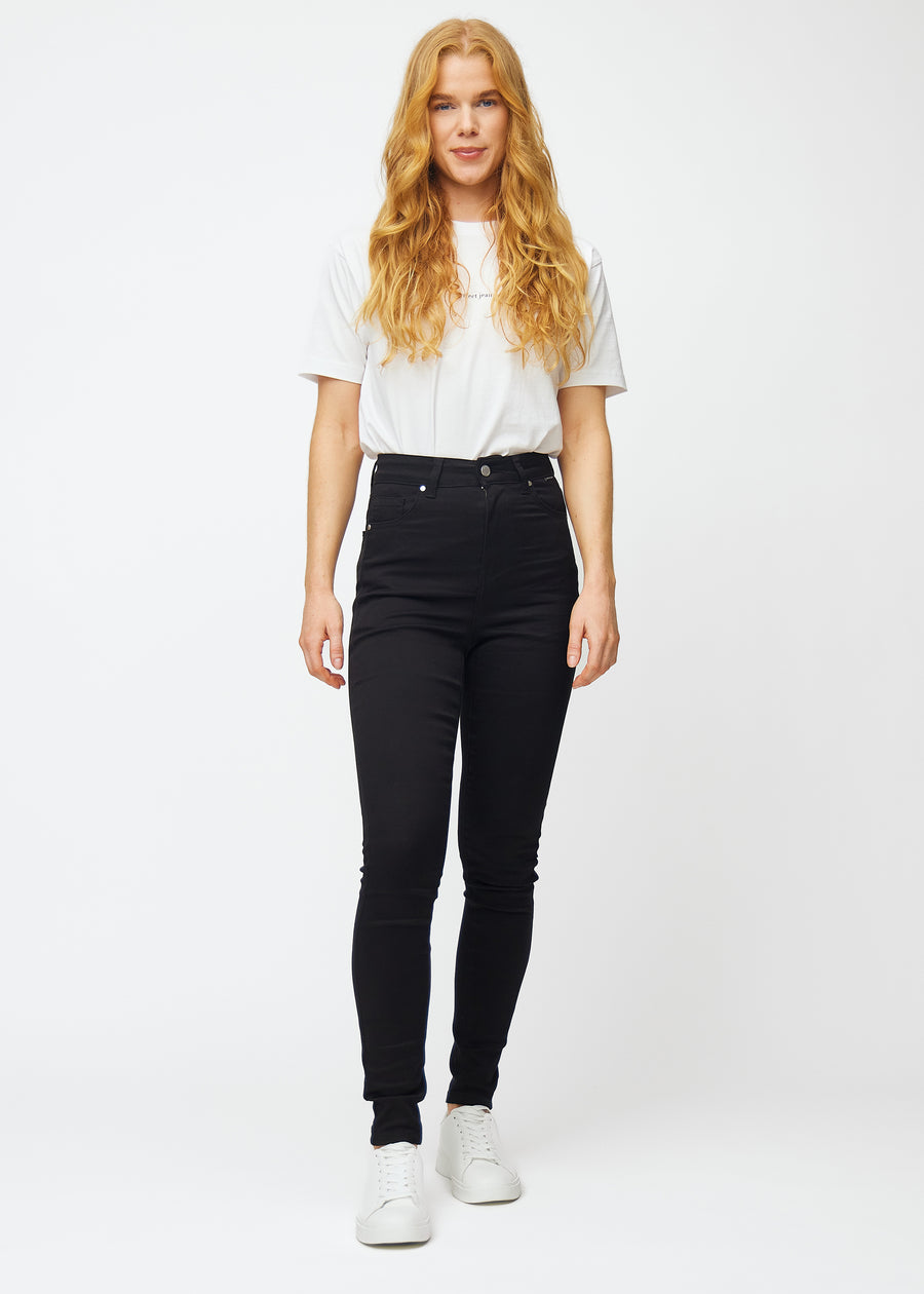 Das Bild zeigt ein komplettes Outfit mit einem Model in schwarzen High-Rise-skinny jeans für Damen in der Farbe Ravens.