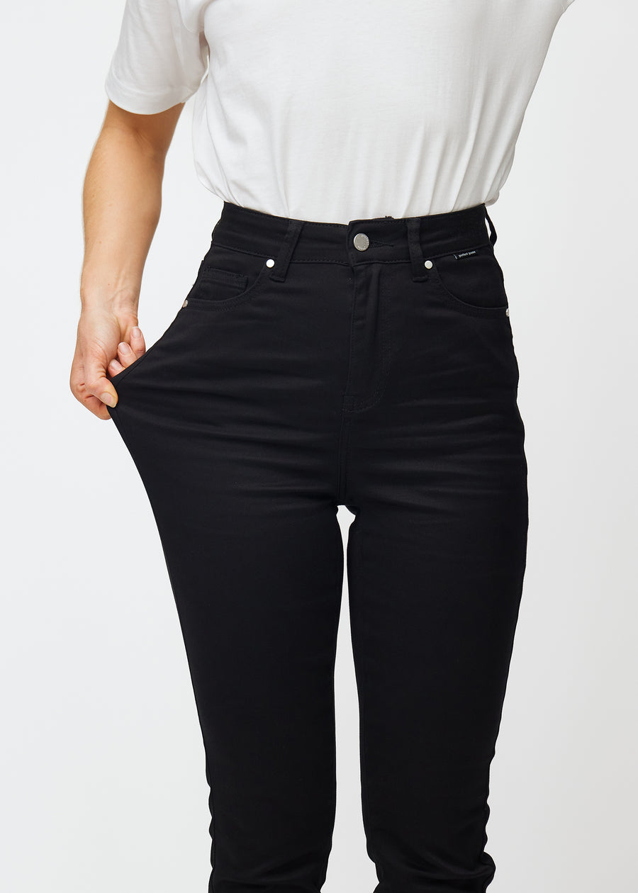 Das Model zieht die Jeans am Oberschenkel auseinander, um den Stretch zu zeigen.
