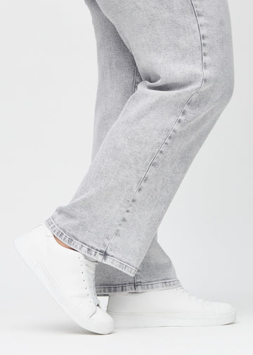 Loose-Jeans für Damen in Hellgrau, Farbe Ashes. Nahaufnahme an den Knöcheln eines Plus-Size-Models, um die weiten Beinabschlüsse zu zeigen.