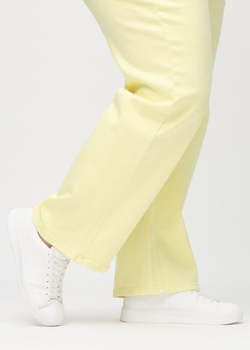 Loose-Jeans für Damen in Hellgelb, Farbe Lemonades. Nahaufnahme an den Knöcheln eines Plus-Size-Models, um die weiten Beinabschlüsse zu zeigen.