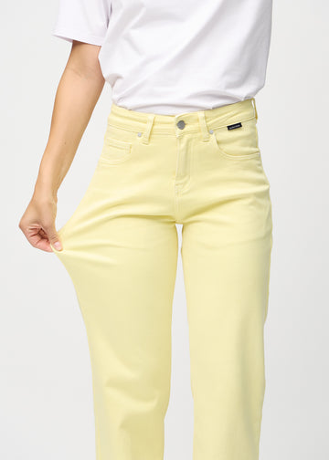 Loose-Jeans für Damen in Hellgelb, Farbe Lemonades. Ein Model dehnt den Jeansstoff am Oberschenkel, um den Stretch zu zeigen.