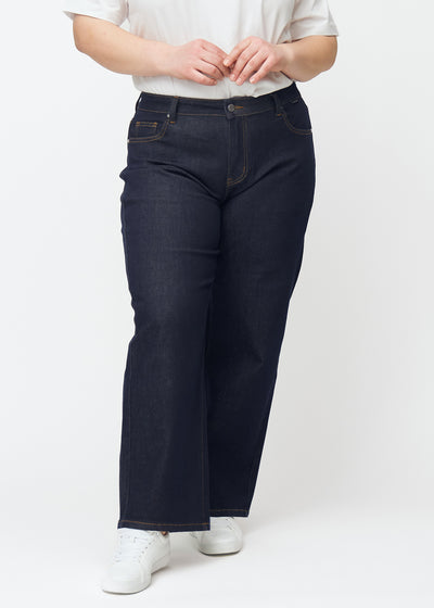 Tief dunkelblaue Denim jeans für Damen in der Farbe Midnights mit loose Passform, von vorn an einem Plus-Size-Model gezeigt.