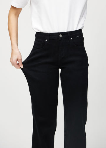 Das Model zieht die Jeans am Oberschenkel auseinander, um den Stretch zu zeigen.