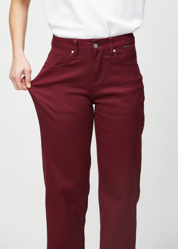 Loose-Jeans für Damen in Dunkelrot, Farbe Santas. Ein Model dehnt den Jeansstoff am Oberschenkel, um den Stretch zu zeigen.