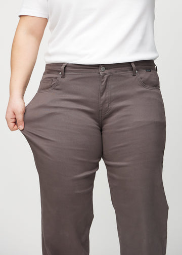 Loose-Jeans für Damen in Graubraun, Farbe Thunders. Ein Plus-Size-Model dehnt den Jeansstoff am Oberschenkel, um den Stretch zu zeigen.