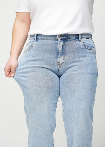 Loose-Jeans für Damen in Hellblau, Farbe Waves. Ein Plus-Size-Model dehnt den Jeansstoff am Oberschenkel, um den Stretch zu zeigen.