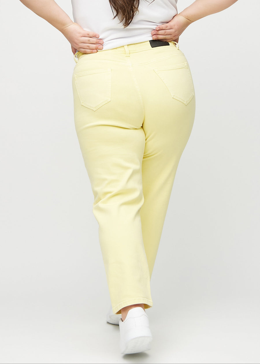 Hellgelbe regular jeans von hinten an einem Plus-Size-Model gesehen, damit man das gesamte Produkt sehen kann.