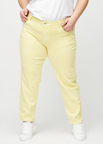 Hellgelbe regular jeans, Modellname Lemonades, die gerade am Bein herunterfallen, an einem Plus-Size-Model von vorne gesehen.