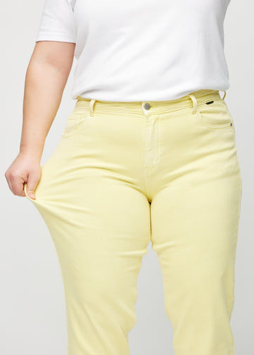 Das Plus-Size-Model dehnt die Jeans am Oberschenkel, um den Stretch zu zeigen.