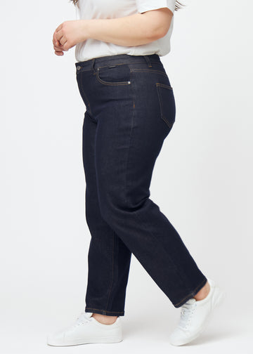 Tief dunkelblaue Denim jeans für Damen in der Farbe Midnights mit regular Passform, seitlich an einem Plus-Size-Model gezeigt.