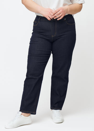 Tief dunkelblaue Denim jeans für Damen in der Farbe Midnights mit regular Passform, von vorne an einem Plus-Size-Model gezeigt.