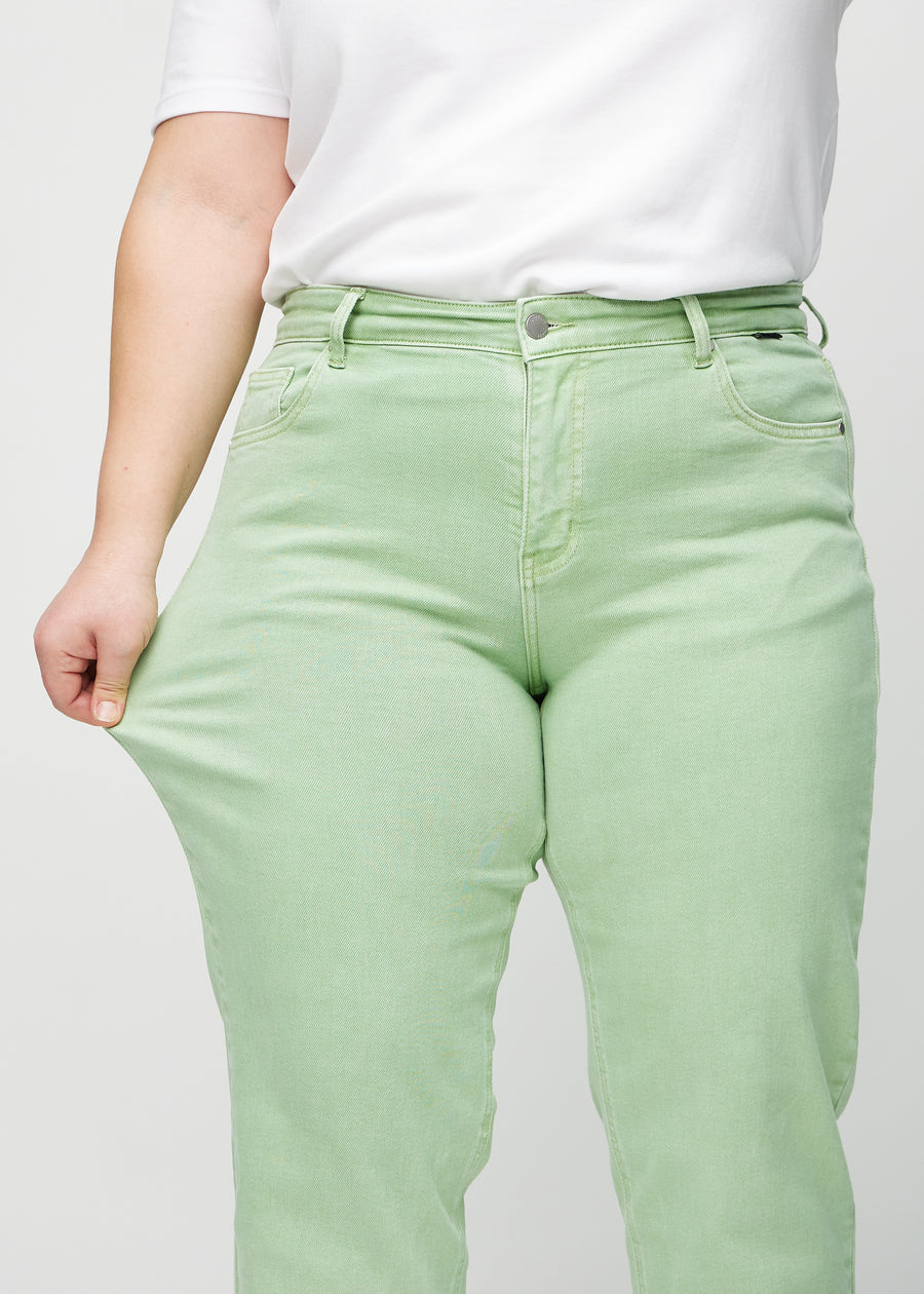 Regular-Jeans für Damen in Hellgrün, Farbe Mints. Ein Plus-Size-Model dehnt den Stoff am Oberschenkel, um den Stretch zu zeigen.